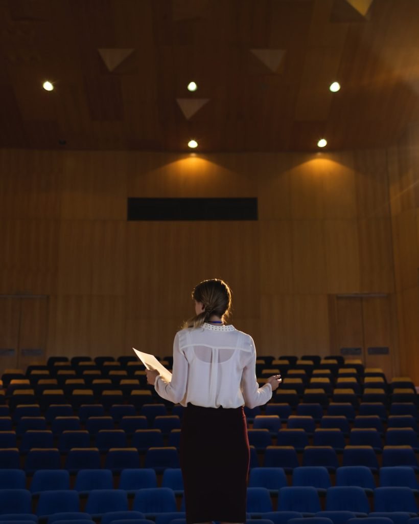beautiful-businesswoman-practicing-and-learning-script-while-standing-in-the-auditorium.jpg